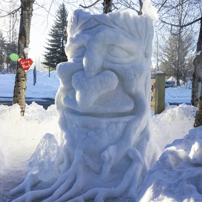 A mythical creature’s face sculpted out of ice and snow.
