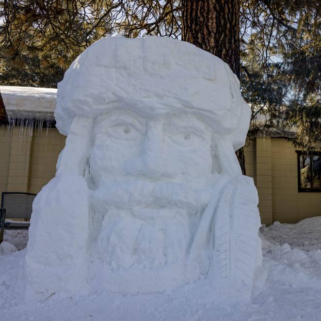 A man’s face sculpted out of ice and snow.