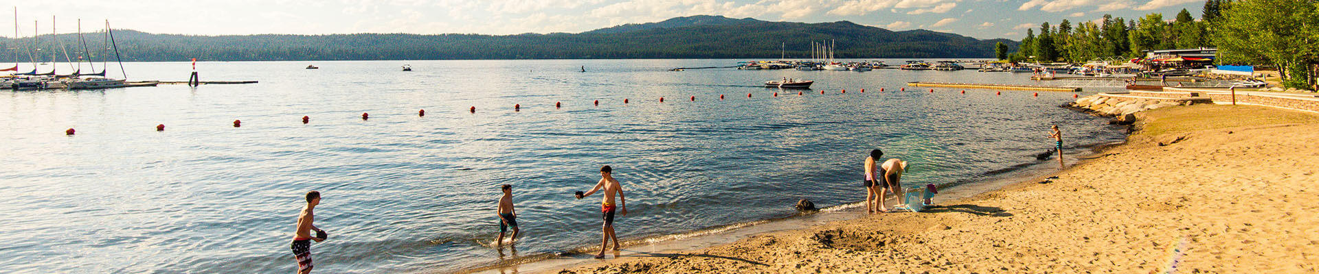 People play on a lakefront beach at Legacy Park in McCall.