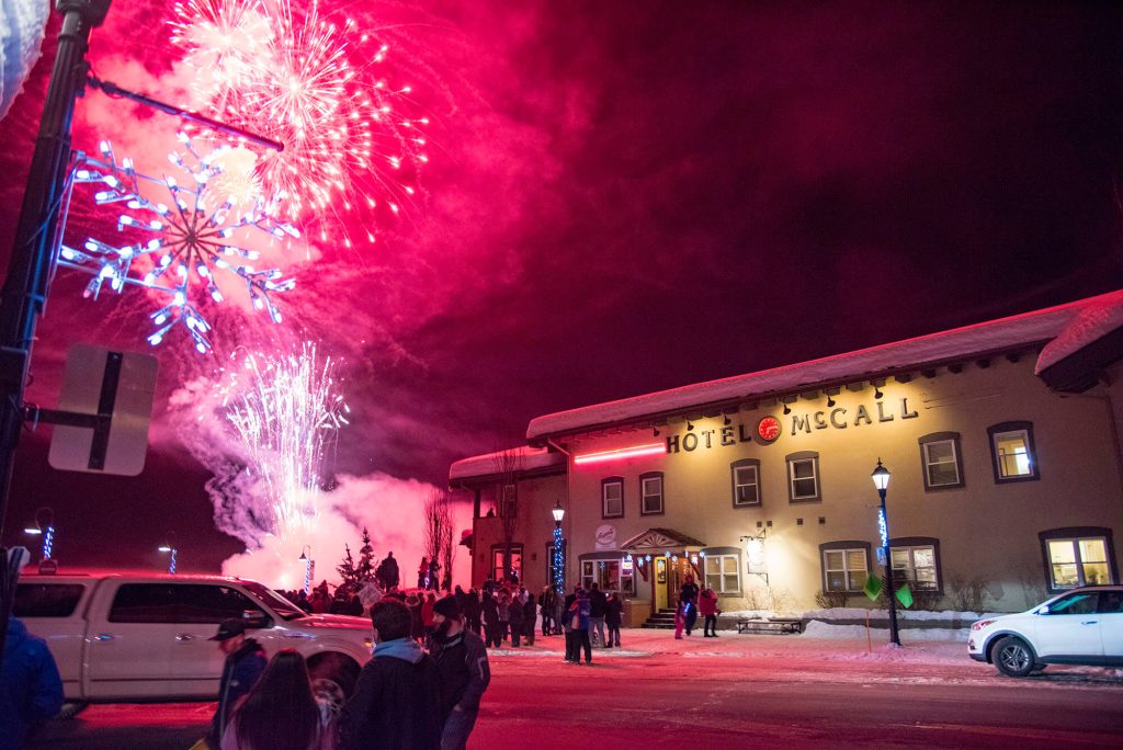 People standing and watching fireworks explode above the Hotel McCall.