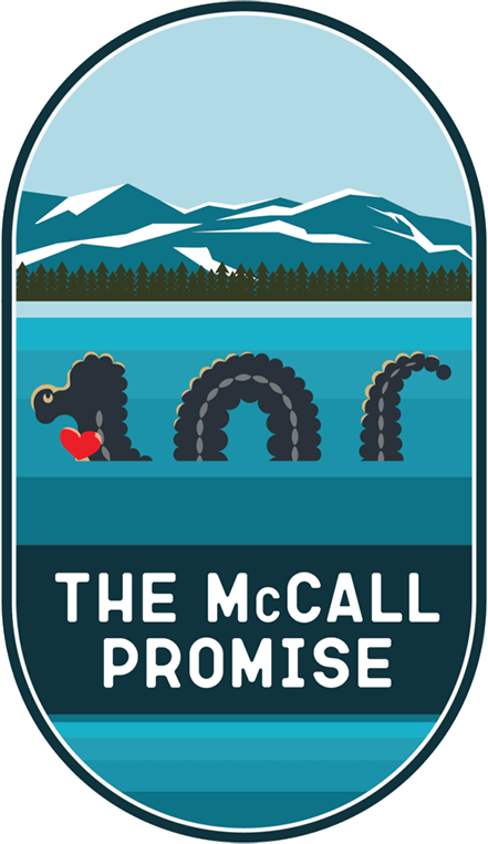 The McCall Promise Badge, depicting the local mythical sea creature, Sharlie, swimming in Payette Lake with a heart.