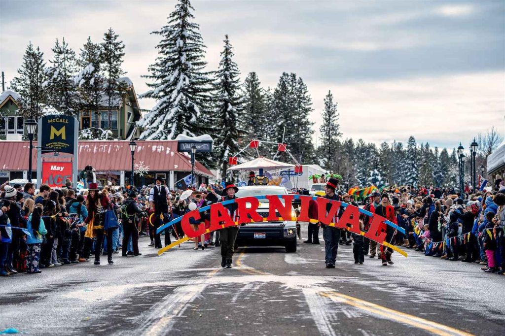 Parade participants march with a sign during the McCall Winter Carnival parade.